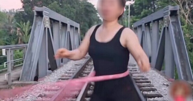 Người phụ nữ vô tư tập lắc vòng trên đường ray tàu hỏa