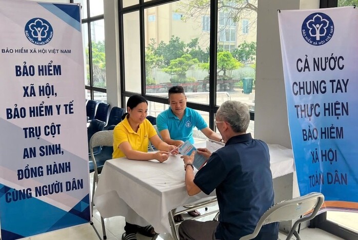 Tư vấn cho người dân về chính sách BHXH, BHYT. Ảnh: BHXH TP Hà Nội