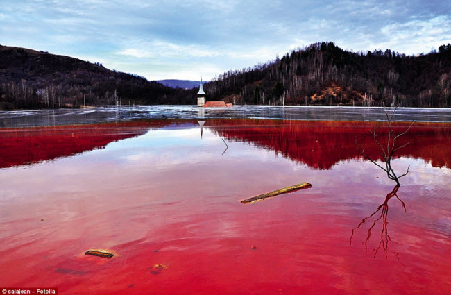 Hồ nước có màu đỏ do ô nhiễm cyanide và các hóa chất khác, nhấn chìm ngôi làng Geamana ở Romania để phục vụ một mỏ đồng ở gần đó. Tất cả những gì bạn có thể thấy là phần chóp của nhà thờ trên mặt nước.