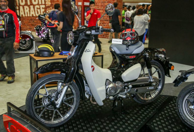 Ở Việt Nam, hiện 2018 Honda C125 Super Cub mới chỉ được nhập nhỏ giọt về từ thị trường Thái Lan. Nhưng với sự xuất hiện tại lễ hội Nghệ thuật Tốc độ 2018 ở Malaysia, rõ ràng Honda C125 Super Cub đang có ý định mở rộng ra khu vực Đông Nam Á. Ảnh C125 Super Cub màu đen trắng xuất hiện tại lễ hội Nghệ Thuật Tốc độ 2018 ở Malaysia.