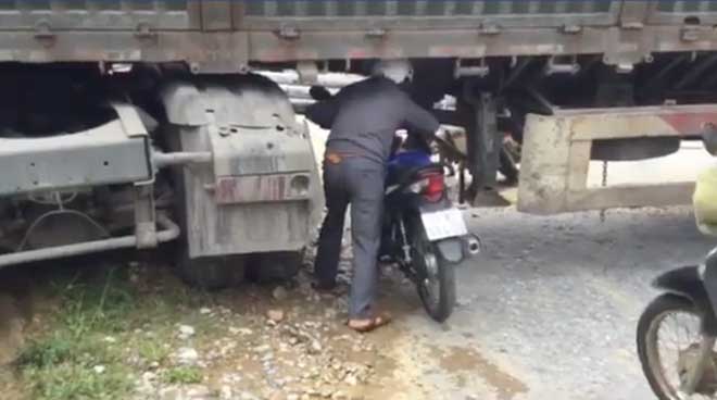 Xe chở cột điện chắn ngang quốc lộ, dân chui gầm xe qua đường - 2