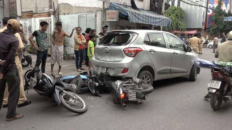 Ô tô "điên" lùi cuốn 3 xe máy vào gầm, nhiều người bị thương - 1