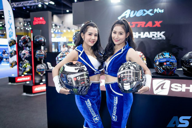 Hai người đẹp bên gian hàng mũ bảo hiểm cho các lái xe mô tô.