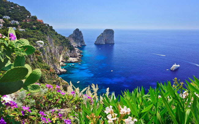 Capri, Italia: Đây là một trong 3 hòn đảo tại vịnh Naples và quê hương của món salad Caprese nổi tiếng. Hòn đảo này thu hút nhiều du khách nhờ phong cảnh đẹp và thời tiết mát mẻ. Địa điểm du lịch hấp dẫn nhất là hang Blue Grotto, với nước biển xanh và chỉ có thể tiếp cận bằng thuyền gỗ.
