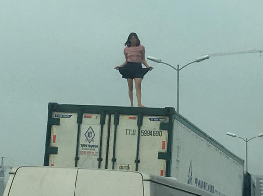 Nóng 24h qua: Vì sao cô gái mặc váy quậy tưng bừng trên nóc xe container? - 1