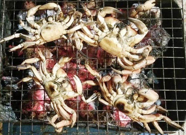 Cua nướng than - một trong những cách chế biến cua đá được nhiều du khách ưa thích.