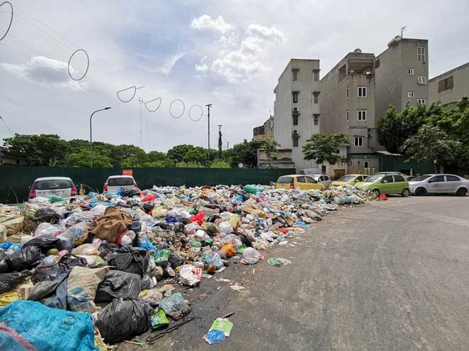 Gần 2 tuần nay, tại nhiều nơi trên địa bàn thành phố Hà Nội&nbsp;xuất hiện nhiều bãi rác ùn ứ, chất thành đống tràn lan vỉa hè và lòng đường. Bãi rác được PV CAND Online ghi nhận hôm nay (9-7) hình thành tự phát kéo dài gần một cây số này nằm ở khu vực ngã tư đường Triều Khúc và Đường Tân Triều Mới (xã Tân Triều, Thanh Trì, Hà Nội).