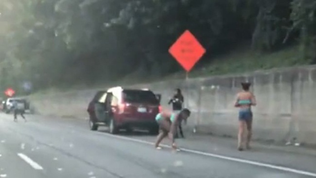 Nhiều lái xe dừng ô tô để nhặt các tờ tiền.