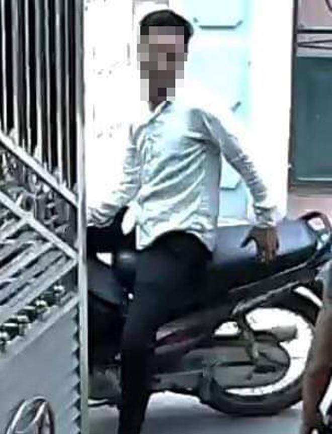 Một người đàn ông trung tuổi khác ngồi trên xe máy đợi ở ngoài.