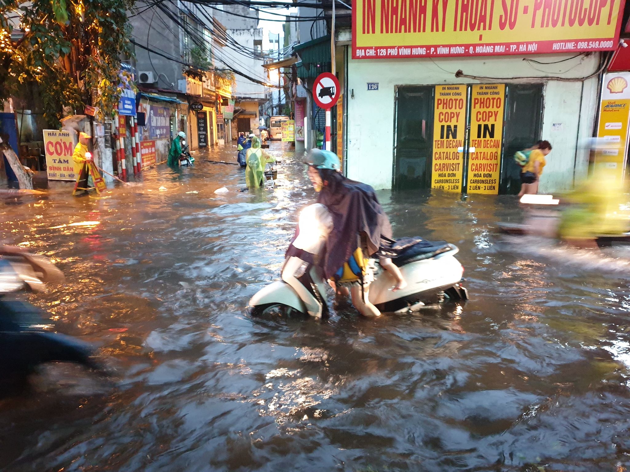 Ghi nhận tại phố Vĩnh Hưng (quận Hoàng Mai), nước ngập sâu khoảng nửa mét khiến nhiều xe máy gặp khó khăn trong việc di chuyển.