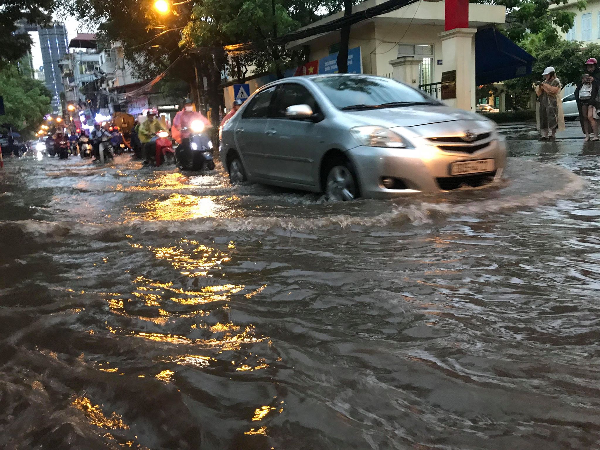 Đường Trần Bình (quận Cầu Giấy) ngập sâu chừng 30-40cm khiến nhiều phương tiện gặp khó khăn khi di chuyển.