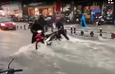 Nước chảy cuốn xe máy của người dân trên đường Võ Văn Ngân