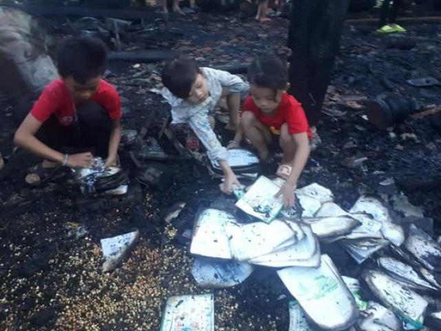 Cháy nhà khi bố mẹ đi chữa bệnh, 3 đứa trẻ bới đống tro tàn tìm sách vở