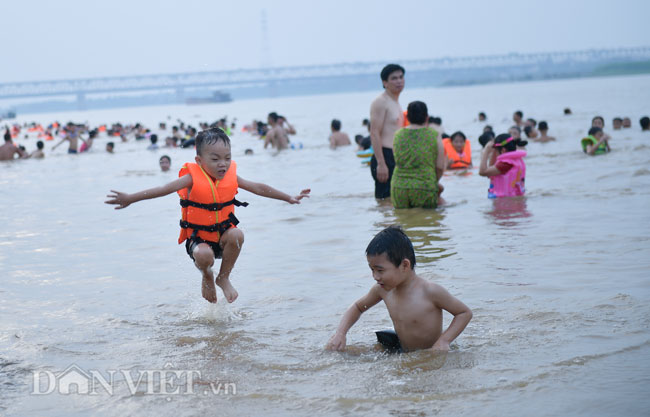 Người dân Hà Nội kéo đến các bãi tắm dọc sông Hồng từ sau 17h để tắm giải nhiệt trong thời tiết nắng nóng hơn 40 độ C.