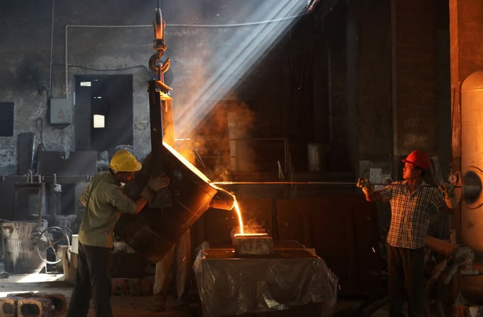Công nhân làm việc tại một nhà máy ở TP Hàng Châu – Trung Quốc hôm 24-7 Ảnh: REUTERS