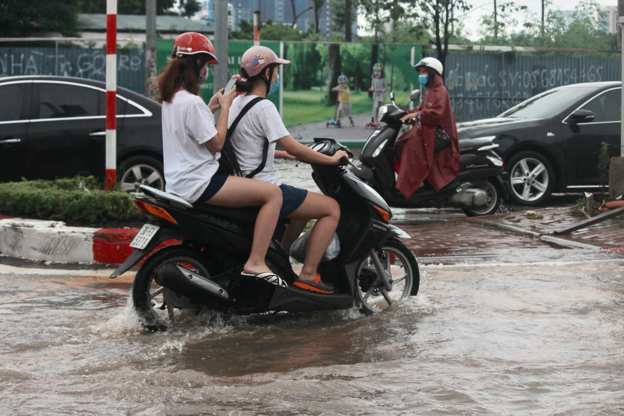 Nhiều người đi sát giải phân cách giữa đường Tố Hữu do lòng đường bị ngập sâu.