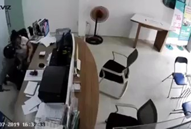 Tài rút dao uy hiếp nữ nhân viên để cướp.