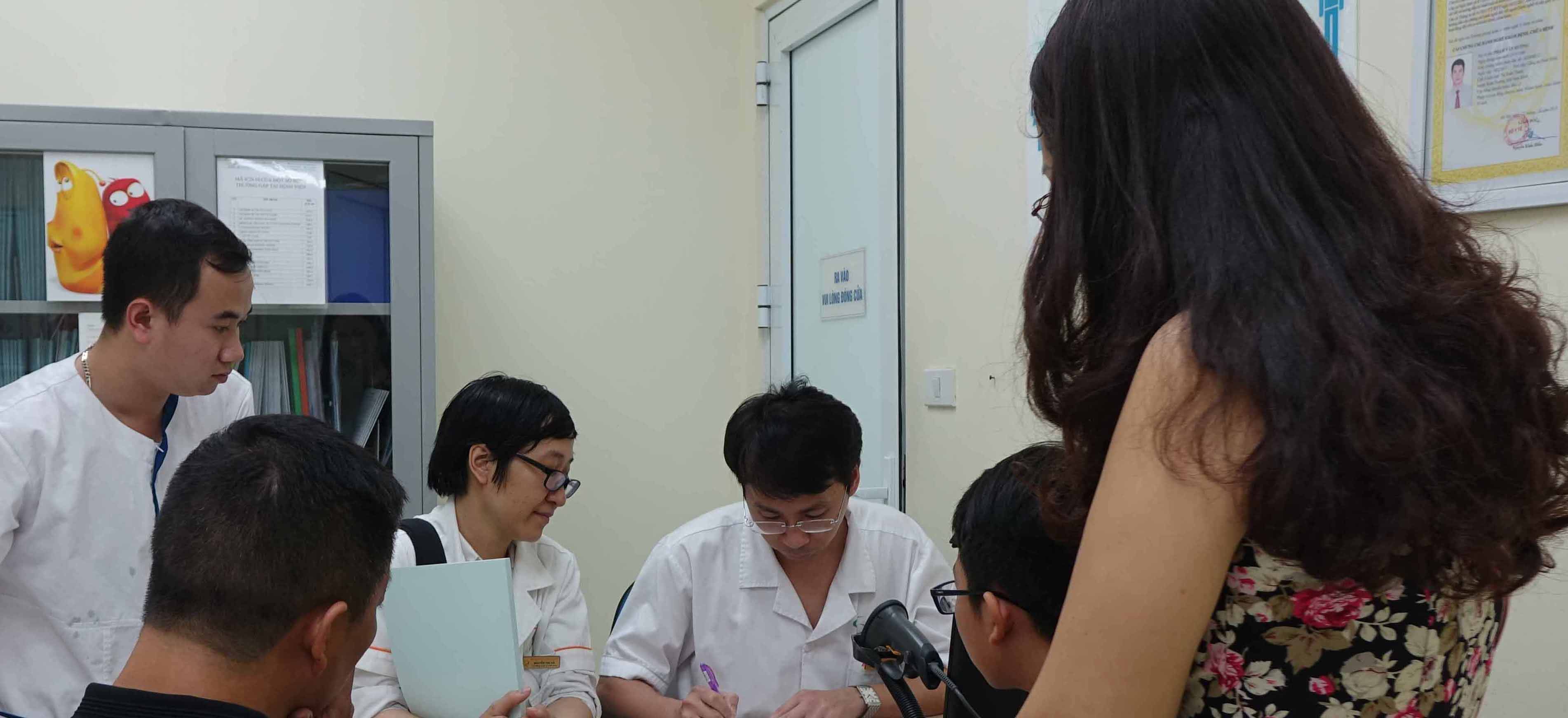 Ths. BS Đinh Hữu Việt (áo trắng thứ 3 từ bên trái sang) đang khám và tư vấn cho bệnh nhân.