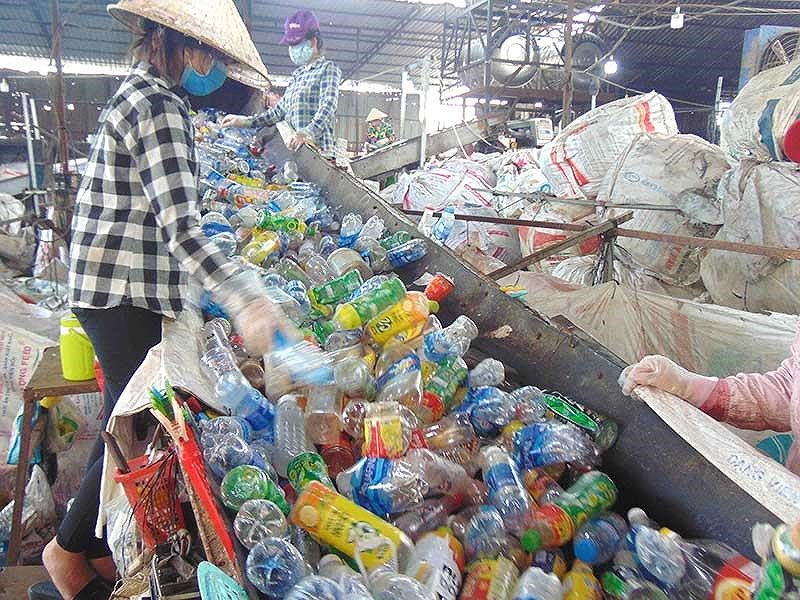 Chai nhựa các loại được băng chuyền chuyển lên máy cắt tại cơ sở B (quận Bình Tân, TP.HCM).&nbsp;