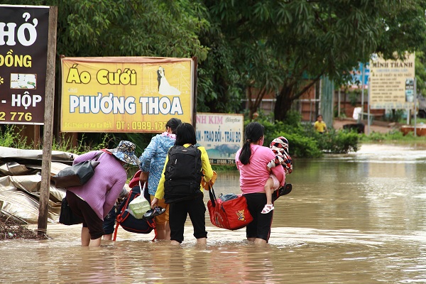 Người dân mang đồ đạc bì bõm lội nước tìm nơi ở tạm chờ nước rút.