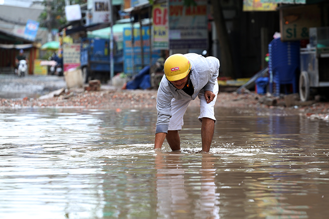 Thanh niên mò “ao nước” trên đường Nữ Dân Công để tìm tài sản bị rơi.