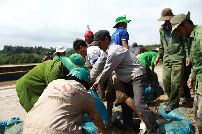 Người dân dùng bao đất để chặn bờ đê, ngăn nước chảy vào ruộng.