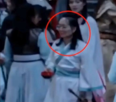 Một diễn viên quần chúng mang kính cận trong phim cổ trang