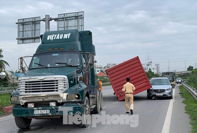 Thùng container bay xuống đường đè trúng xe ô tô ở quận 9. Ảnh: Văn Minh