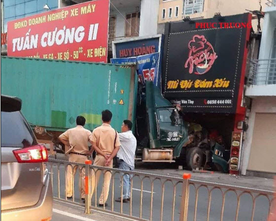 Xe container tông sập mặt tiền của hai cửa hàng.