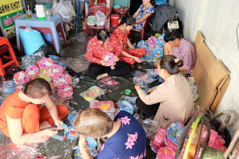 Các nhân công đang gắn đèn cho loại lồng đèn điện tử. Ảnh: THU HÀ