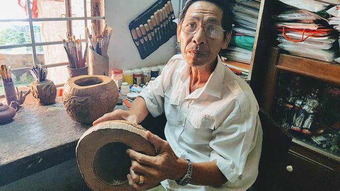 Ông Đặng Hồng Điểm điêu khắc trên vỏ dừa khô chuẩn bị giao cho khách