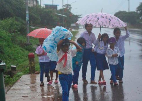 Nhiều em không mang áo mưa hoặc ô nên phải chung nhau che mưa đi về.