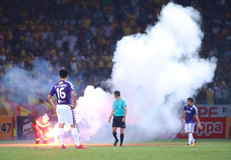 Pháo sáng bắn xuống
sân lia lịa khiến trọng tài Ngô Duy Lân phải cho dừng trận đấu vì
không bào đảm an ninh, an toàn. Ảnh: NGỌC DUNG.