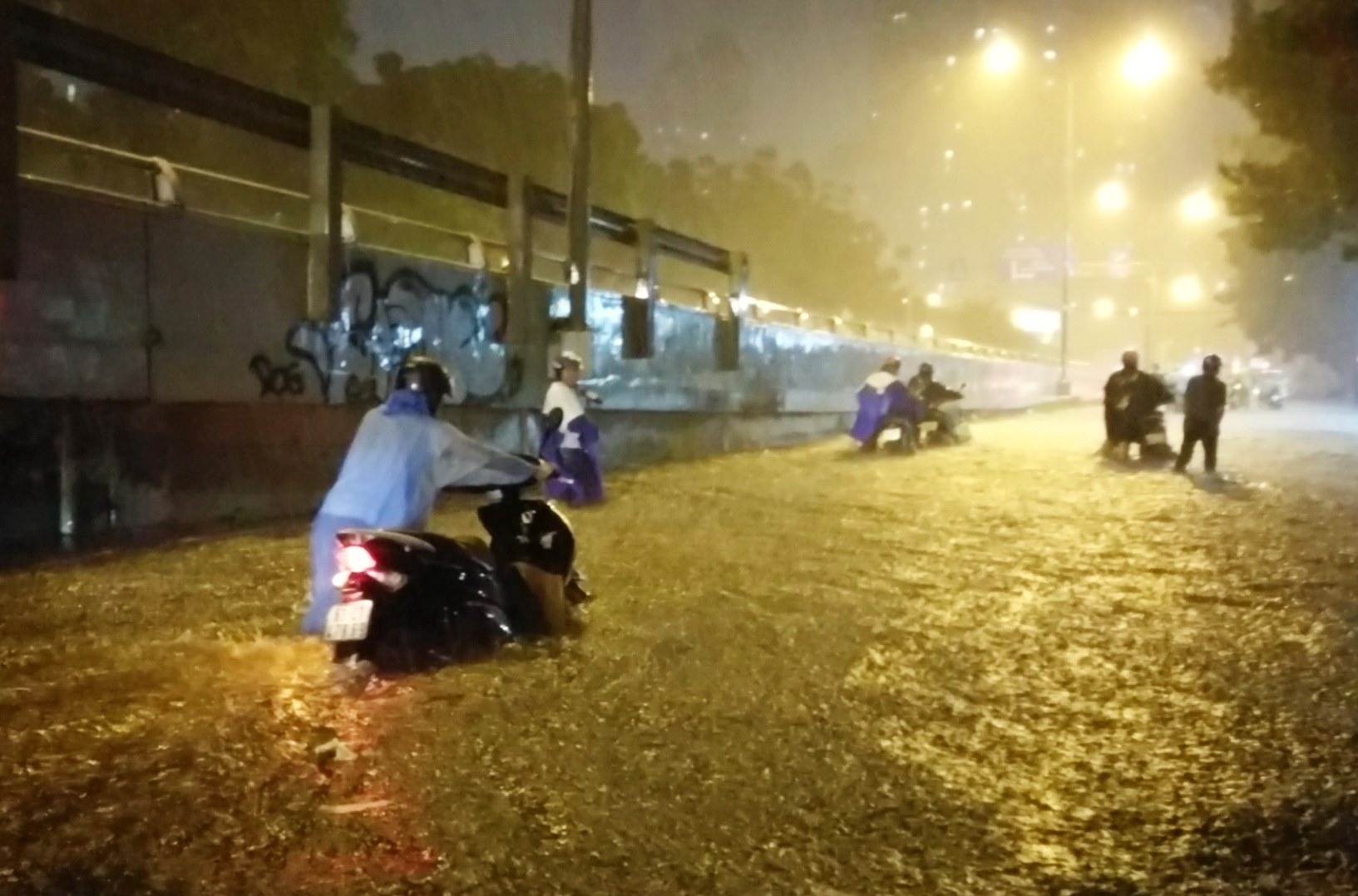 Xe chết máy đoạn chân cầu vượt Nguyễn Hữu Cảnh, dân phải hì hục đẩy xe vượt qua đoạn ngập nước.