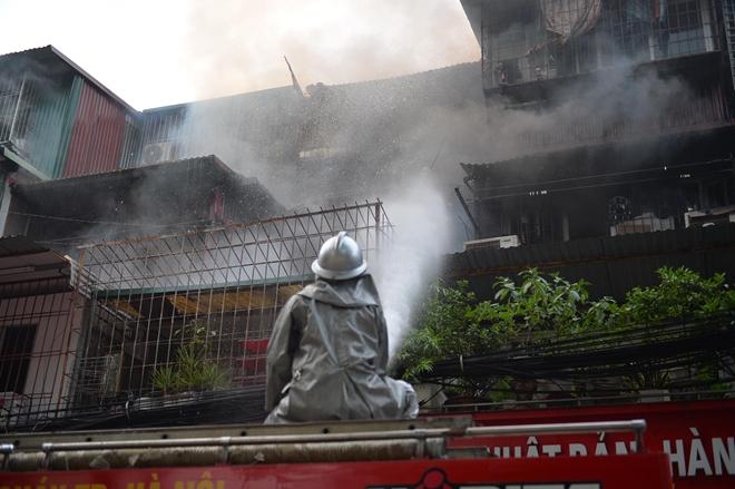 Lính cứu hỏa phun nước khống chế ngọn lửa từ phía ngoài của khu tập thể.