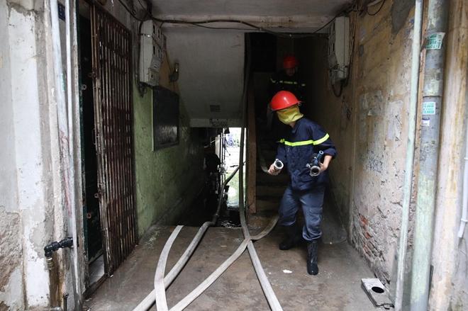 Lực lượng cảnh sát PCCC kéo dây đưa nước lên sát hiện trường ở tầng 4 để dập lửa.