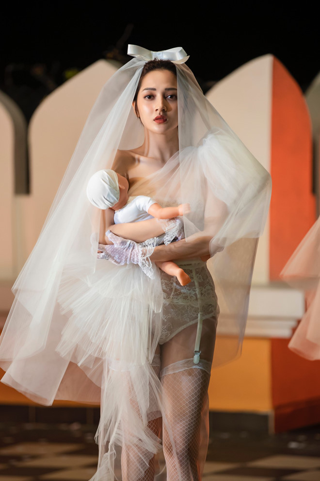 Nếu coi MV của Bảo Anh là một show thời trang thì chắc chắn bộ váy cưới xuyên thấu này chính là chủ nhân cho vị trí vedette. Chất liệu ren và voan được sử dụng triệt để nhưng nóng bỏng hơn vì thân váy là bodysuit.&nbsp;