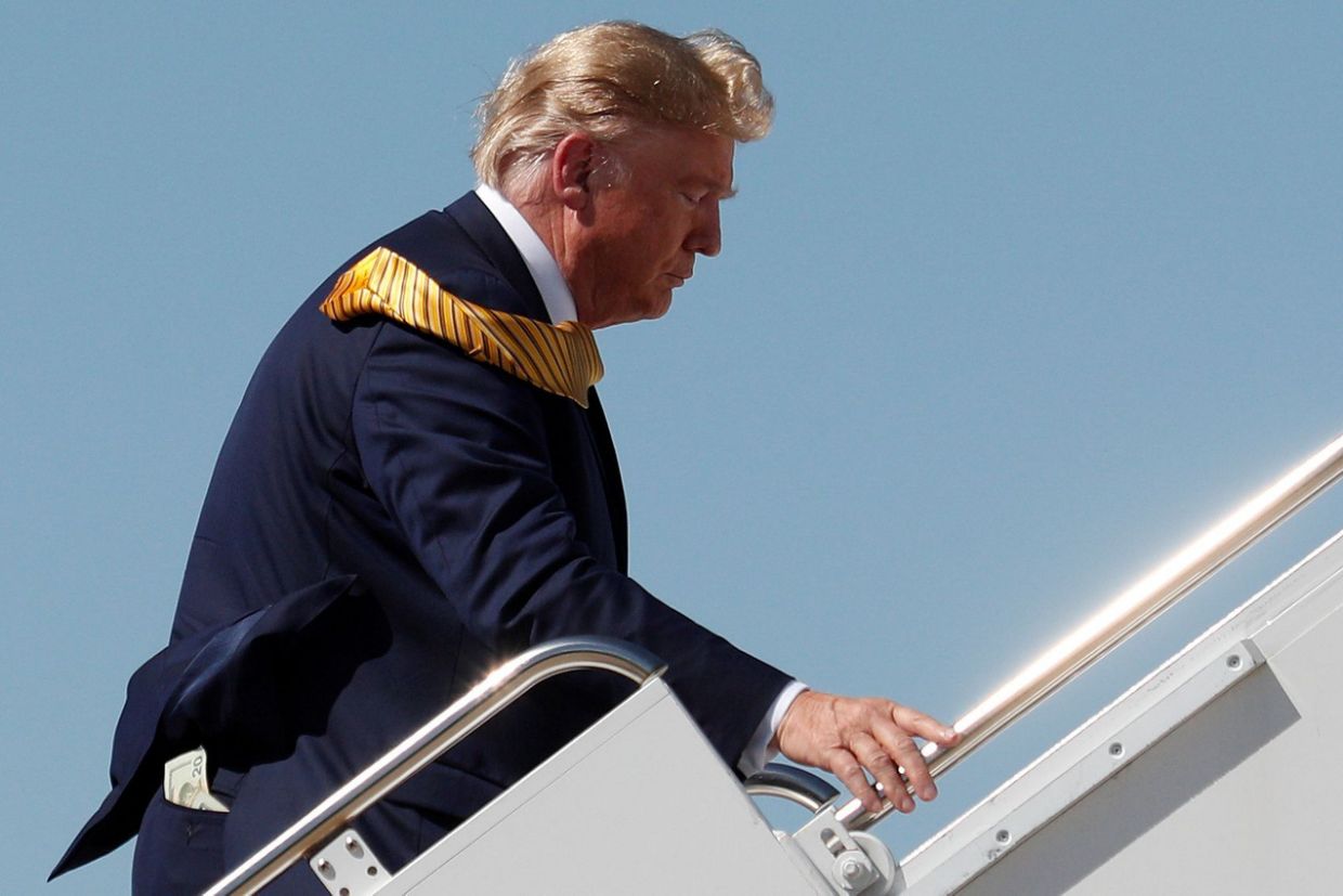 Ông Trump bị bắt gặp để lộ một xấp tiền lẻ ra khỏi túi quần khi lên máy bay (Ảnh: Reuters)