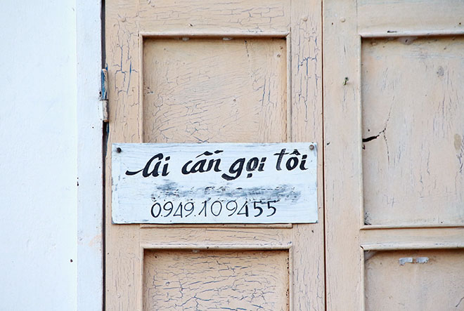 Số điện thoại cùng dòng chữ “Ai cần, gọi tôi” trước cửa nhà để mọi người có thể liên lạc với ông khi cần