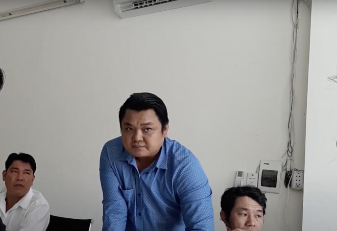 Ông Ngô Minh Khâm (áo xanh) lúc chưa bị bắt