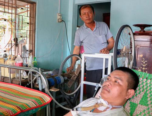 Lão nông Trần Trung Hiếu và con trai bên máy trợ thở tự chế tạo