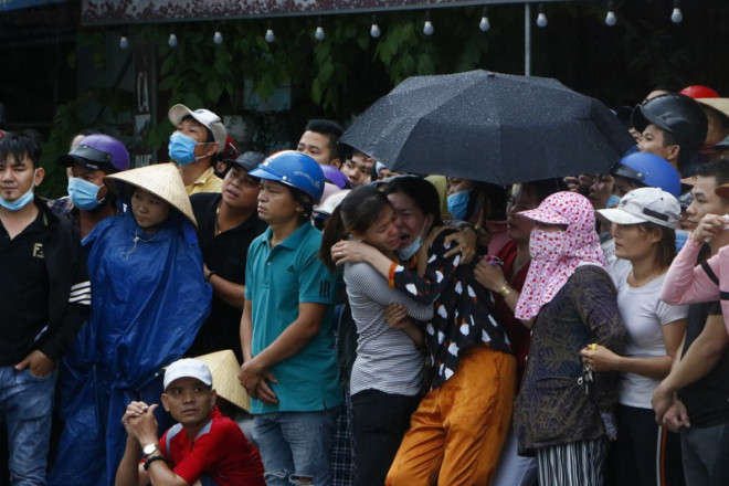 Người nhà các nạn nhân gào khóc thảm thiết khi các thi thể được đưa ra ngoài. Ảnh: LÊ ÁNH