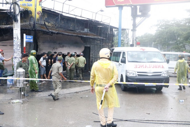 Lực lượng chức năng khám nghiệm hiện trường trong mưa. Ảnh: LÊ ÁNH