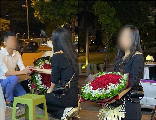 Hình ảnh bạn trai quỳ xuống cầu hôn cô gái. Vì ngại nơi đông người, cô nàng miễn cưỡng nhận bó hoa.