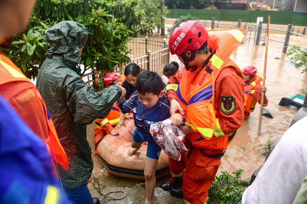 Một em bé được giải cứu ở Giang Tây trong cơn lũ (ảnh: Xinhua)