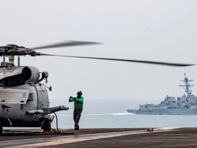 Trực thăng đa năng MH-60R Sea Hawk được đại tu trên boong tàu sân bay USS Ronald Reagan, bên phải là tàu khu trục USS Mustin có tên lửa dẫn đường, tại Biển Đông ngày 9-7. Ảnh: US NAVY/AP