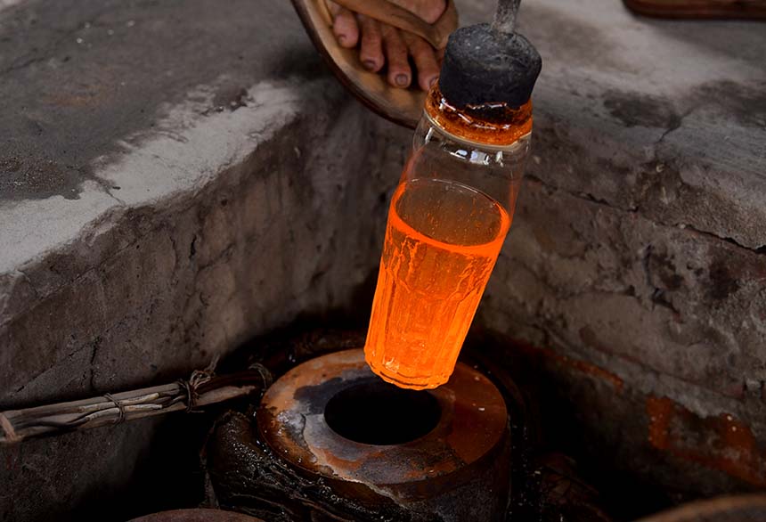 Thủy tinh nóng chảy được đưa vào khuôn và người thợ dùng hơi thổi mạnh để tạo hình cho chiếc cốc.