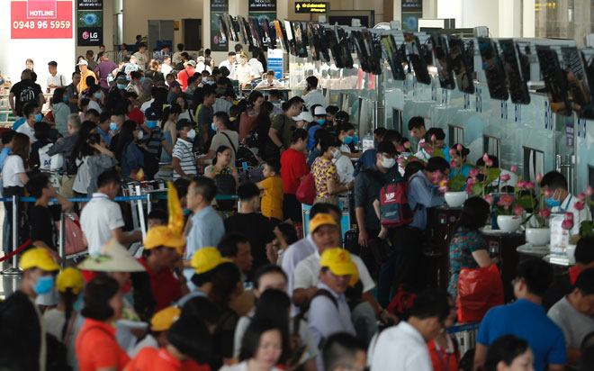 Hành khách đợi đến lượt vào làm thủ tục check-in tại sân bay Nội Bài, nhiều người tỏ ra mệt mỏi vì phải xếp hàng và chờ quá lâu.