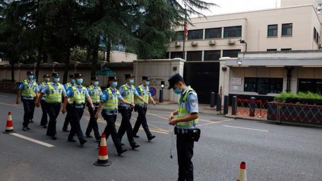 Các sĩ quan cảnh sát Trung Quốc tuần hành qua lãnh sự quán Mỹ tại Thành Đô. Ảnh: NG HAN GUAN / AP