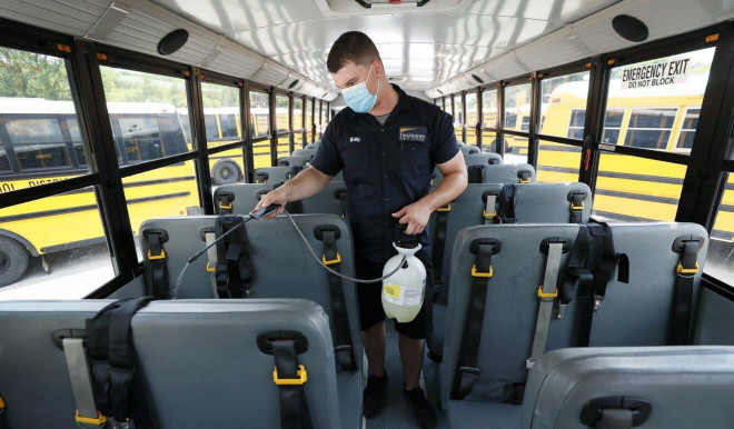 Một nhân viên khử trùng xe buýt tại Iowa hôm 29-7. Ảnh: AP